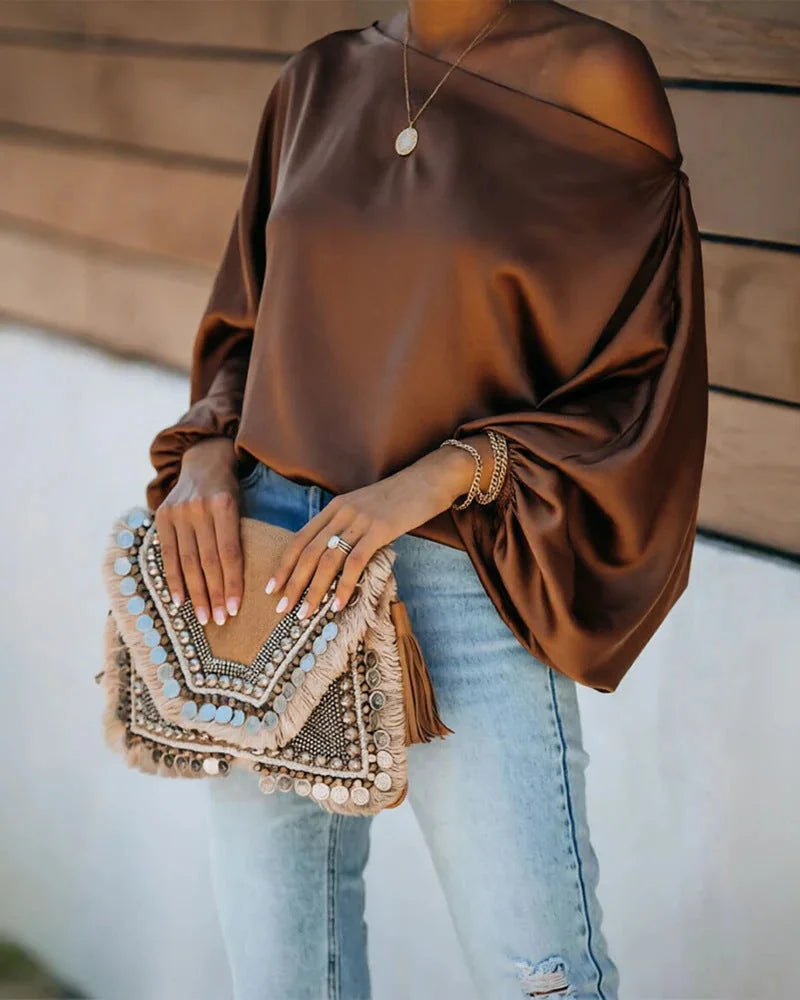 Women's Satin Blouse with Asymmetric Off-Shoulder Neckline & Batwing Sleeves - Brown Outdoor Pose Clutch